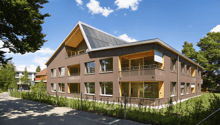 3 story building, brown exterior, solar panels on roof, multiple balconies, large windows