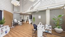 Interior design with white walls, wooden floor, multiple white chairs, lamps, desk, plants