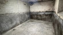 empty garage with concrete floor and walls, ceiling with fluorescent light