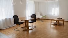 empty room, wooden floor, white walls, curtains, wooden table, two chairs, white armchair, green table, table lamp