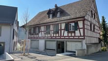 2 story house, brown roof, white and brown walls, garage