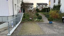 Brick paved area with greenery, a small hill in the middle, concrete pavements