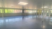 wide open room, white ceilings, concrete floor, large windows, skylight