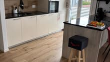 white kitchen, wood floor, island, oven, sink, modern appliances