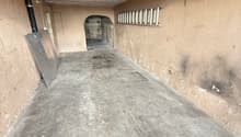 Empty concrete floor, wooden ceiling, ladder on the wall, small hole in the wall