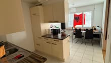 kitchen with dining area, white tiles, wooden countertops, white cabinets, chandelier, dining table, chairs, flags