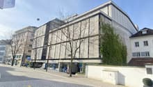 Modern building with glass windows, white walls, and a parking sign