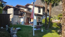 2 story house, brown roof, white walls, balcony, garden, patio, mountain view