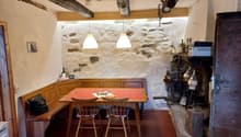 wooden table, chairs, stone walls, fireplace