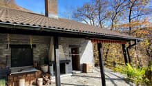 Stone house, chimney, fireplace, wooden porch, wooden storage boxes, logs, plants