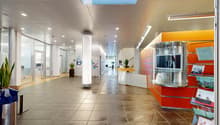 spacious lobby, light grey floor tiles, tall glass walls, white and orange walls, metal column, plants