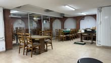 Wooden tables and chairs, tiled floor, brick wall, glass wall, tables in another room