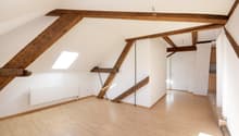 empty room, wooden beams, wooden floor, white walls, radiator, skylight
