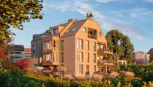 Modern apartment building, beige exterior, multiple balconies, circular windows, rooftop terrace, surrounded by greenery