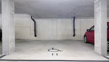 underground parking garage, concrete walls, white floor, designated parking spot number 11