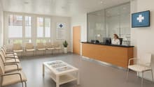 Clean and bright reception area with a desk, chairs, books on a table, a plant, and a TV monitor displaying a logo on the wall.