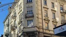 Facade of a building, three floors, several balconies, windows with shutters