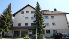 3 story house, beige exterior, multiple windows, garage, car parked in front
