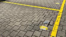 A brick paved parking lot with yellow markings