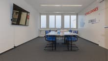 empty room, desk, chairs, flatscreen TV mounted on wall, windows, carpeted floor