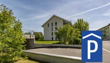 modern building, parking area, trees, grassy lawn, clear blue sky, parked car sign