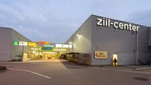 Commercial building, elevated ground, signage, wide parking area, multiple shops