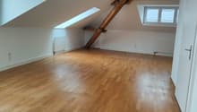empty room, wooden floor, wooden beams, windows, radiators