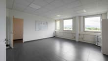 empty room, white walls, gray tiles, three windows, open door, radiators, bulletin board