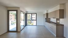 empty room, large windows, sliding glass doors, tiled floor, kitchen area