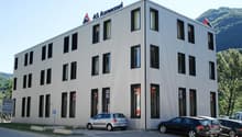 modern office building, multiple windows, cars parked in front