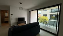 modern apartment, glass wall, couch, flat screen tv, balcony with table and chairs, hardwood floor