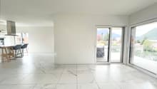 large open space, white marble flooring, white walls, large sliding glass doors, balcony, view of mountains