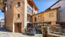 3 story house, beige walls, brown door, balcony, car parked in garage