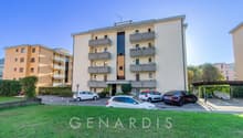 4 story building, beige exterior, multiple balconies, parking lot, multiple cars parked
