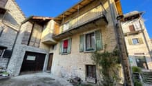Two story house with stone wall, balcony, garage