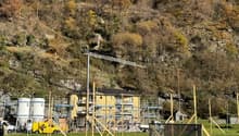 Building under construction, steel scaffolding, solar panels, yellow building, tanks, road