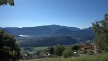 hillside with grass, trees, mountains, lake, town, construction site