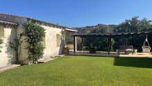 House with outdoor sitting area and pergola, garden, climbing plants on the wall, outdoor table and chairs, swing, lawn