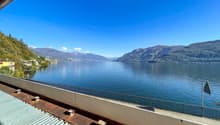 View from the terrace of the lake, mountains, and surrounding buildings.
