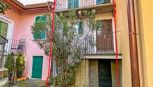 2 story house, brick facade, green windows, balcony, brick sidewalk