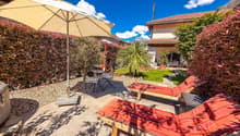 outdoor area with loungers, patio umbrella, small table, mountain view