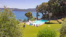 grassy lawn, swimming pool, chairs, pool side tables, view of the sea