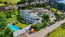 Three-story apartment building, swimming pool, parking spaces, fenced yard, trees