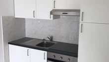 white cabinets, black countertop, stainless steel sink, stainless steel oven and stove, exhaust hood