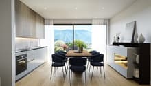 Modern kitchen with wooden table and chairs, glass door leading to balcony, wooden floors, white cabinets, sink, oven