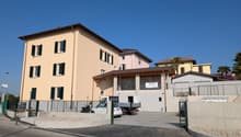 3 story building, beige exterior, multiple windows, parking lot, sign reading 'Vendesi'