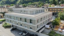 4 story building, concrete exterior, multiple windows, multiple balconies, underground parking, view of town and mountains