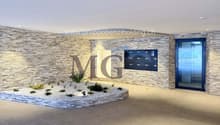 Stone-walled entrance with a small garden area, a letterbox box, and an entrance door