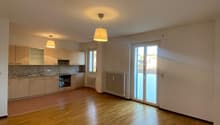 Empty room, open kitchen, wooden floor, white walls, two sliding doors, radiator, modern kitchen with black stove and kitchen island.