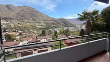 Balcony with tiled floor, metal railing, view of mountains and town
